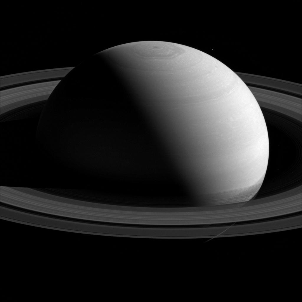 Real NASA Cassini spacecraft photo of Saturn, Capricorn's ruling planet, half-lit against black space with its rings visible